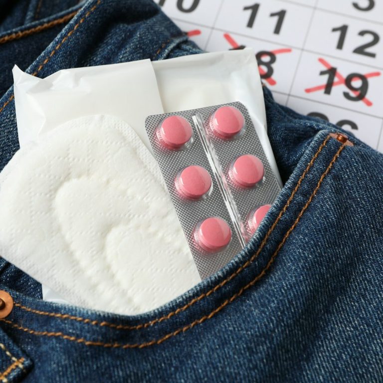 Tasche mit Hygieneartikeln, Medikamentenblister und Kalender mit markiertem Datum.